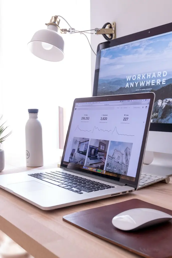 MacBook Pro on table beside white iMac and Magic Mouse